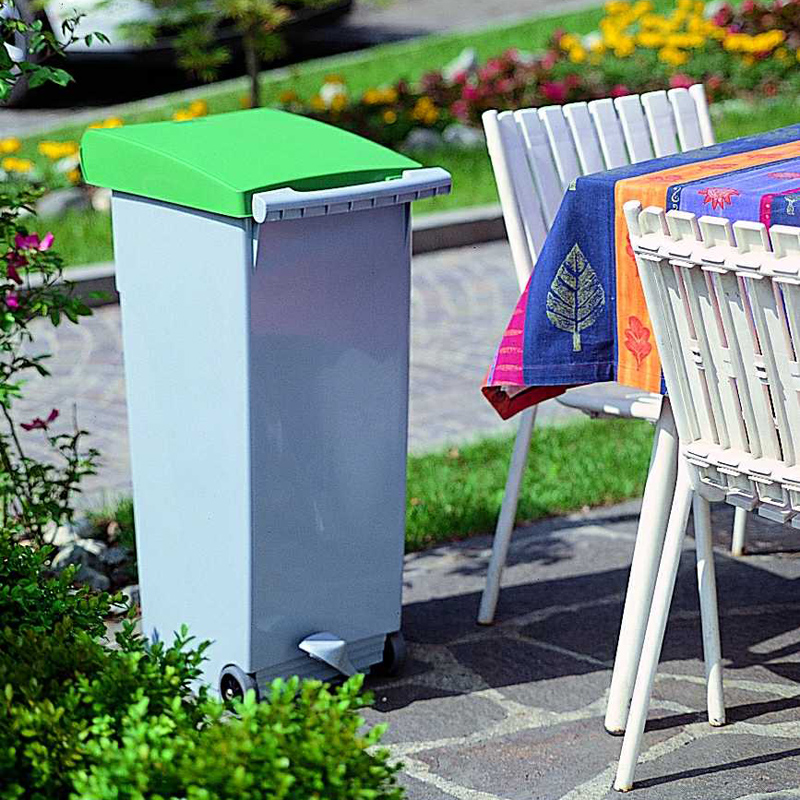 A CLIPPER waste container at tableside in a garden